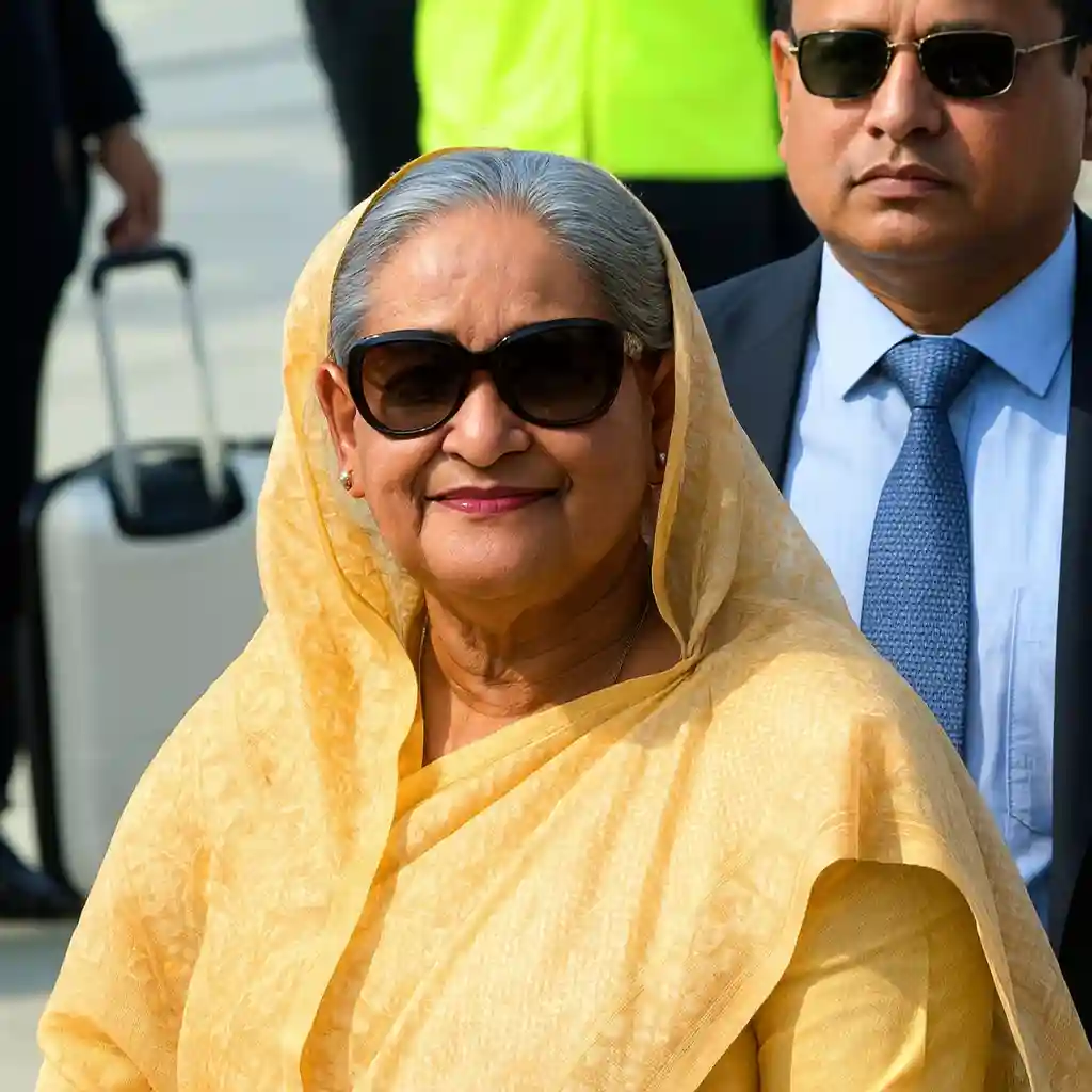 Hasina Death Sentence Bangladesh former Prime Minister Sheikh Hasina arriving with security detail wearing yellow saree and sunglasses